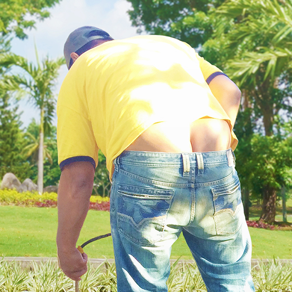 The laborer with his pants sagging and buttcrack exposed in a garden.